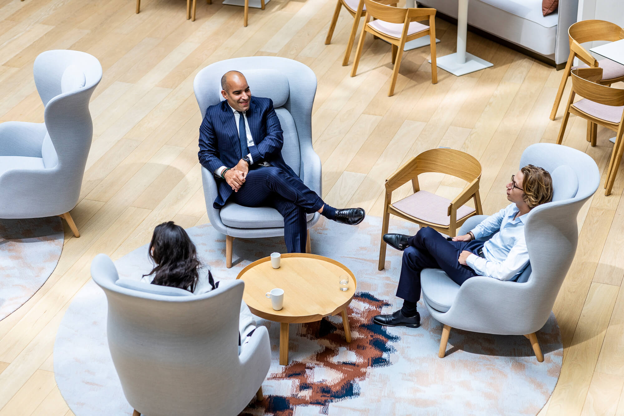 Three Lazard colleagues talking around a low table in the Paris office