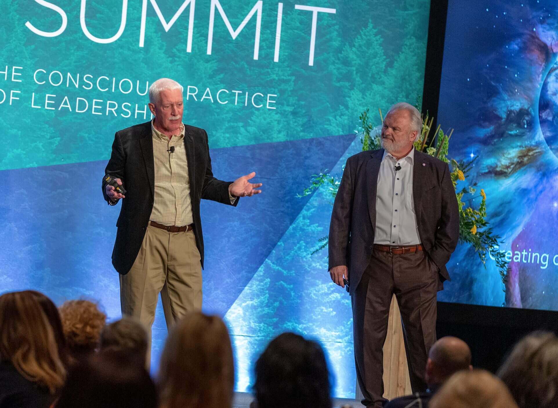 Leadership Circle co-founders Bob Anderson and Bill Adams speaking on a summit stage