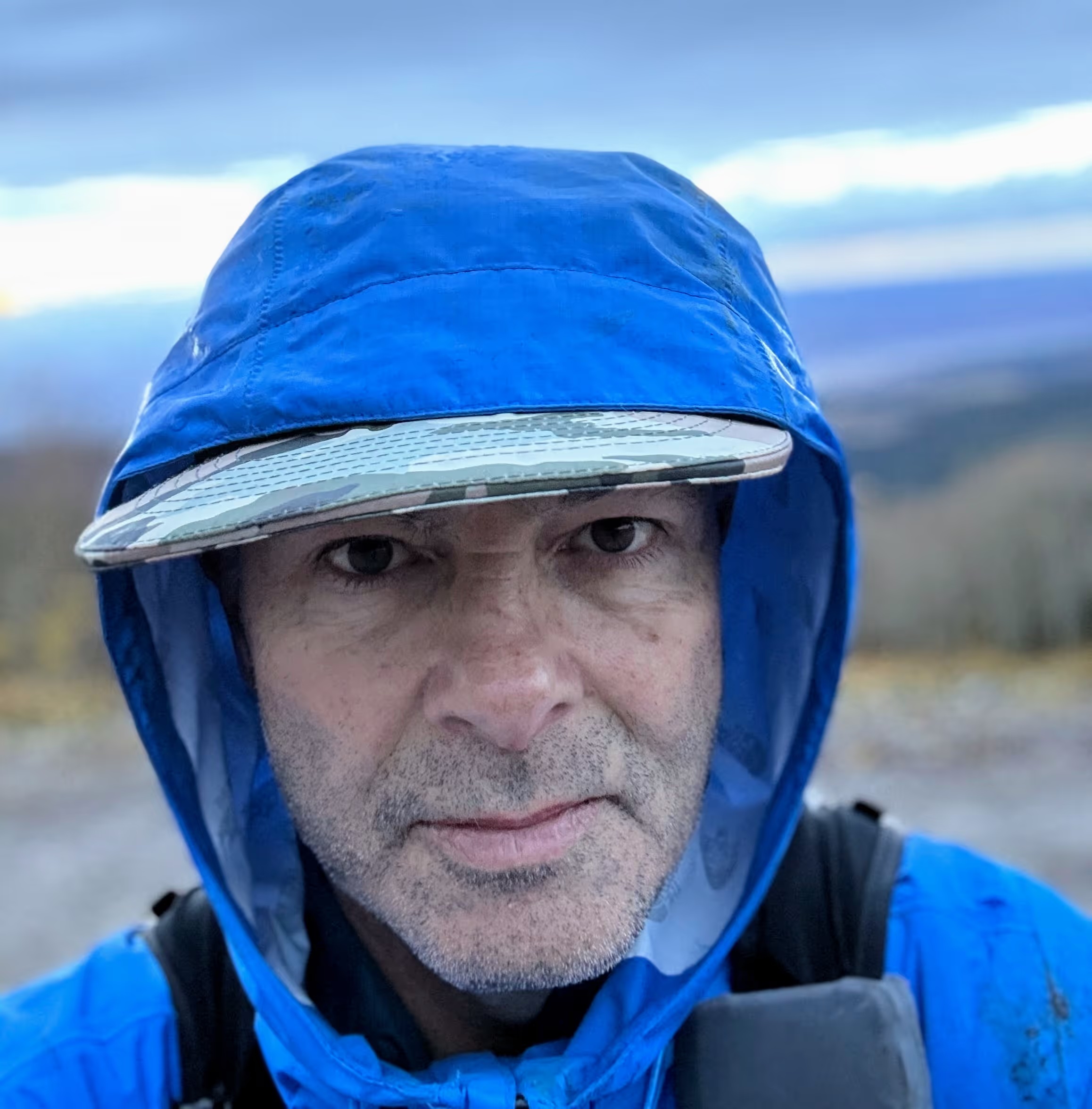 Lee Arthur in a blue hood and cap at mile 205 of the Moab 240
