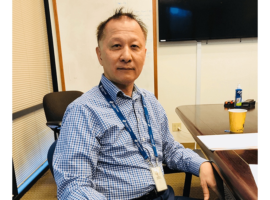 Lee Chen seated at a conference table in a checked shirt during a 2018 interview.