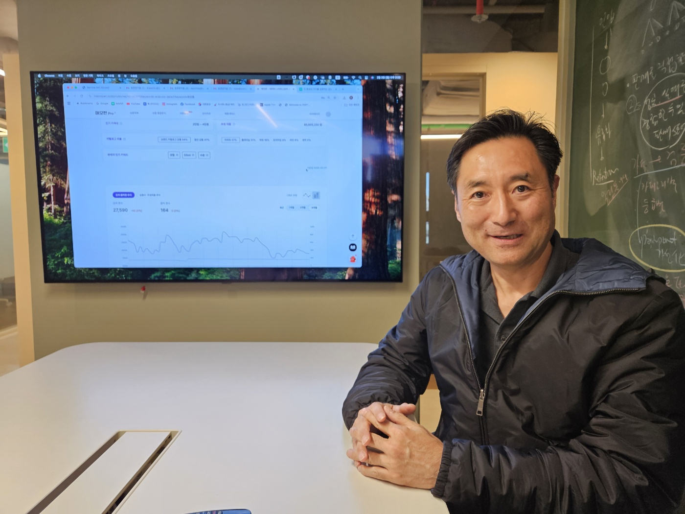 Lee Kyung-ho seated beside a monitor displaying a Maemopan analytics dashboard