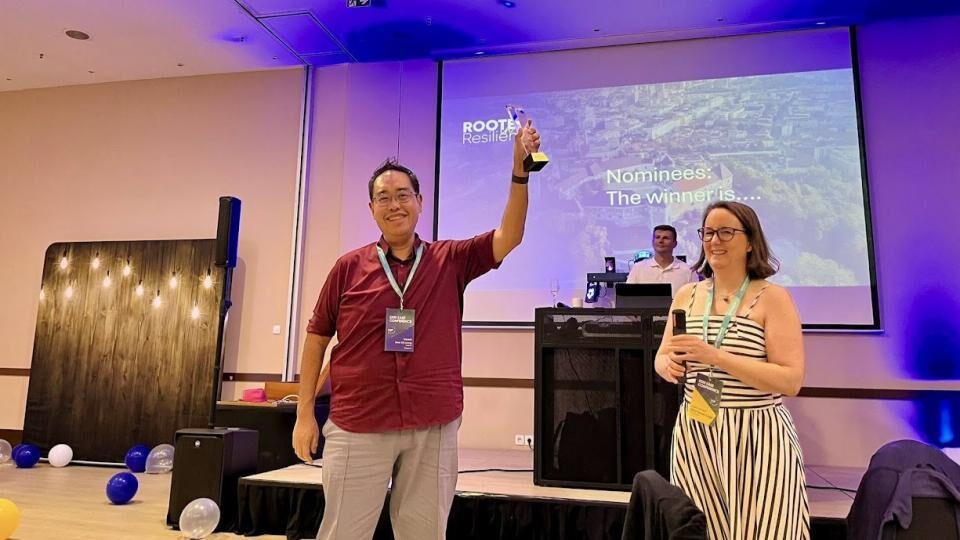 Leon CK Leong raises an award beside EAEF Executive Board Member Ketut David-Liege in Ljubljana