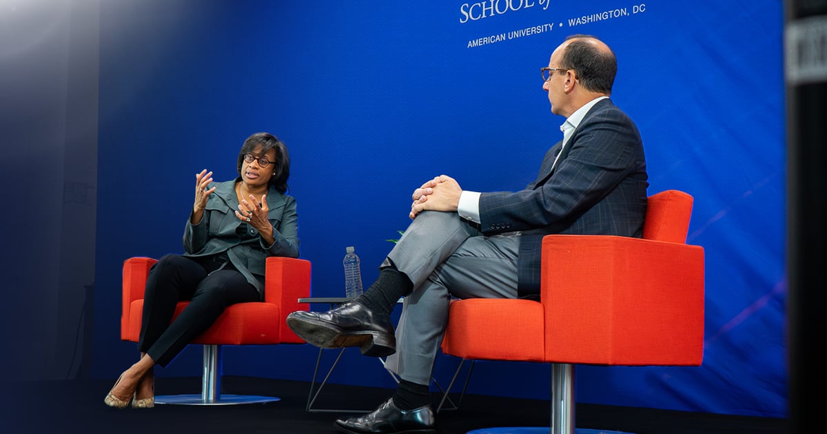 Leslie Hale speaking with Kogod dean David Marchick in two red armchairs