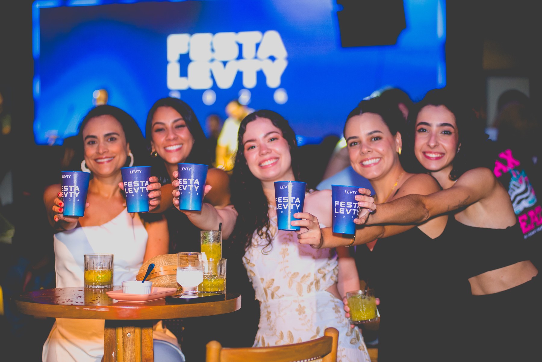 LEVTY employees holding blue company cups at a team celebration