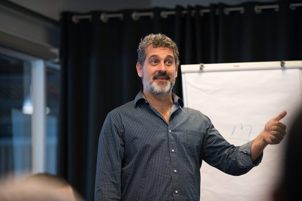Lex Sisney speaking beside a flip chart during a workshop