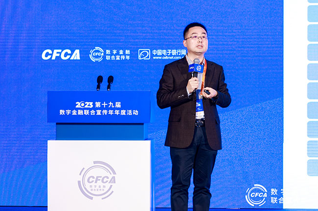 Bruce Li speaking with a handheld microphone at the 2023 digital finance annual event in Beijing