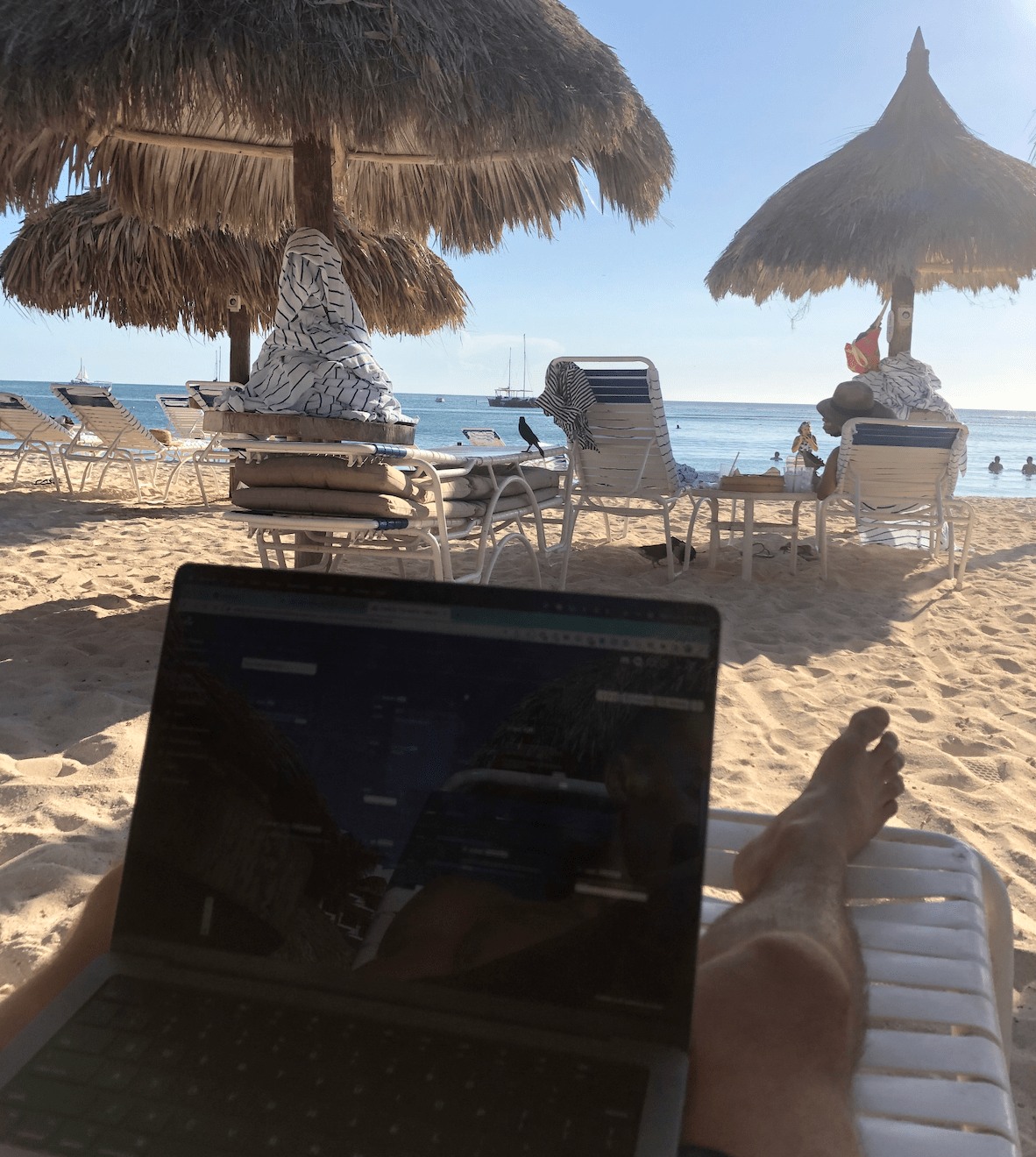 Liam Ottley's laptop beside a beach in Aruba, photographed by him