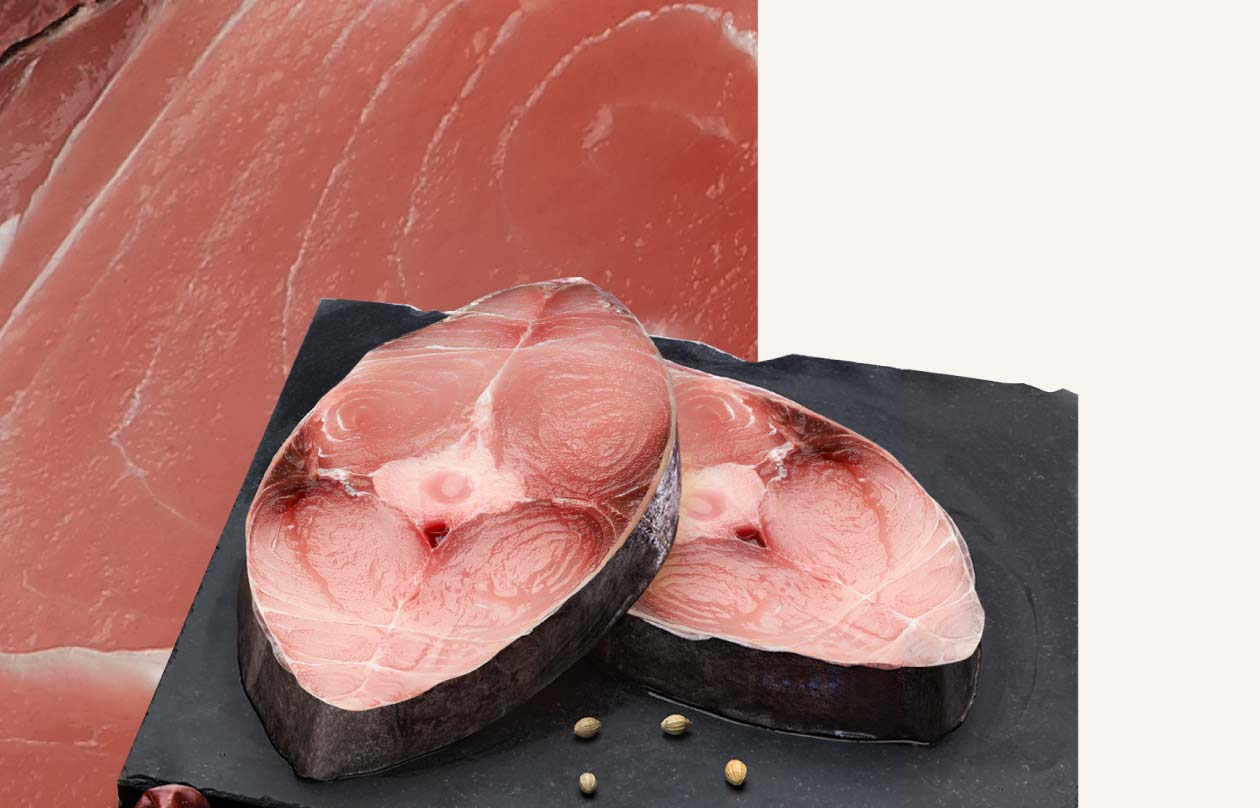 Two thick fish steaks presented on a dark board