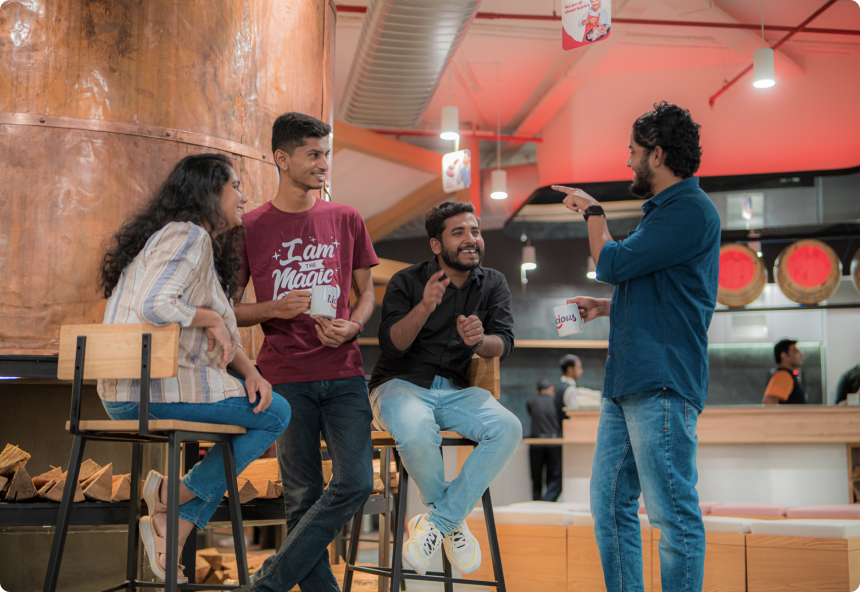 Four Licious team members chatting together with mugs