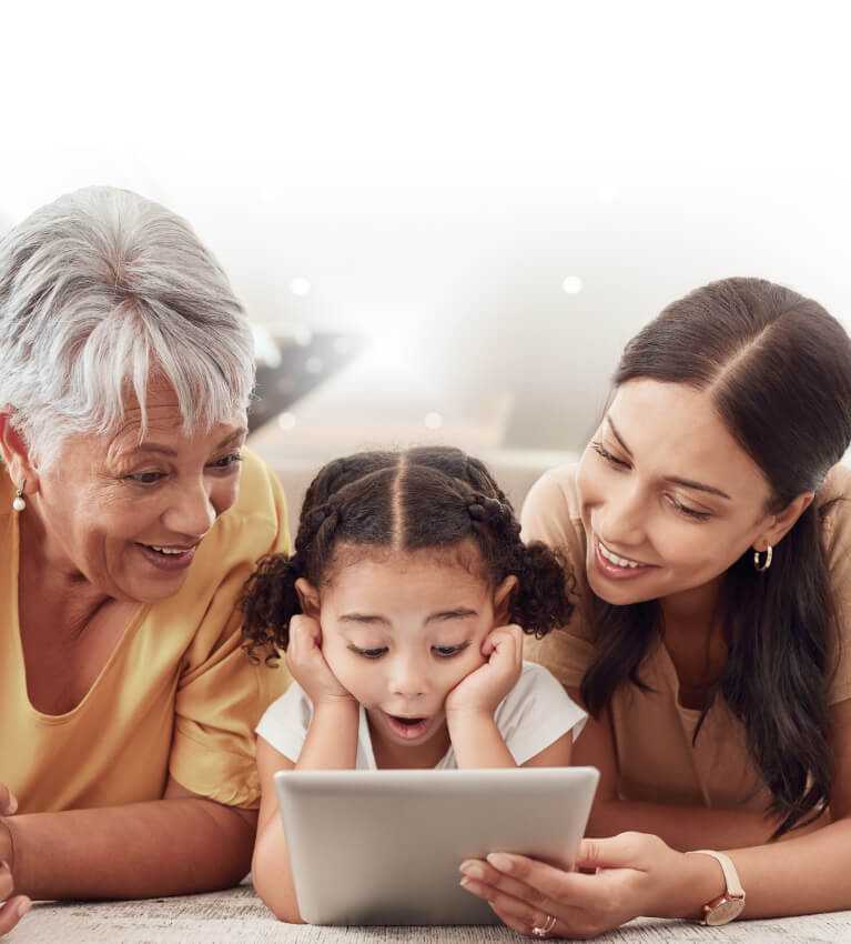 Three generations of women looking together at a tablet