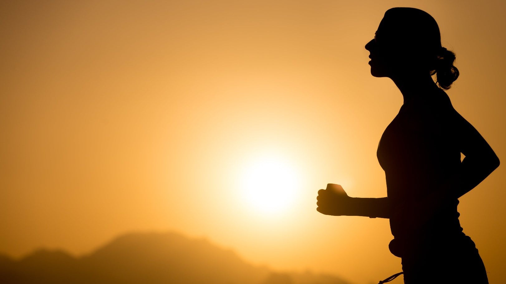 Runner on a mountain trail at dawn