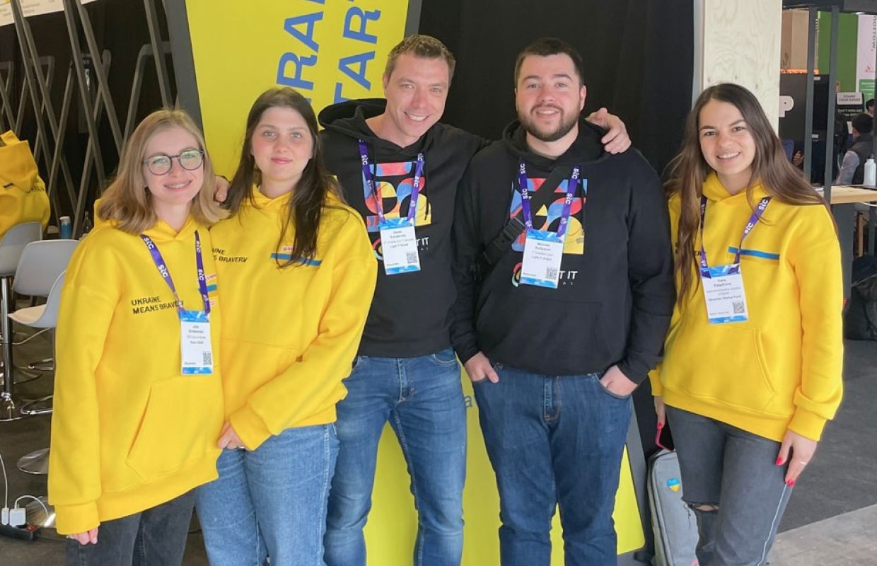 Light IT Global team members together at a conference, wearing yellow and navy tops