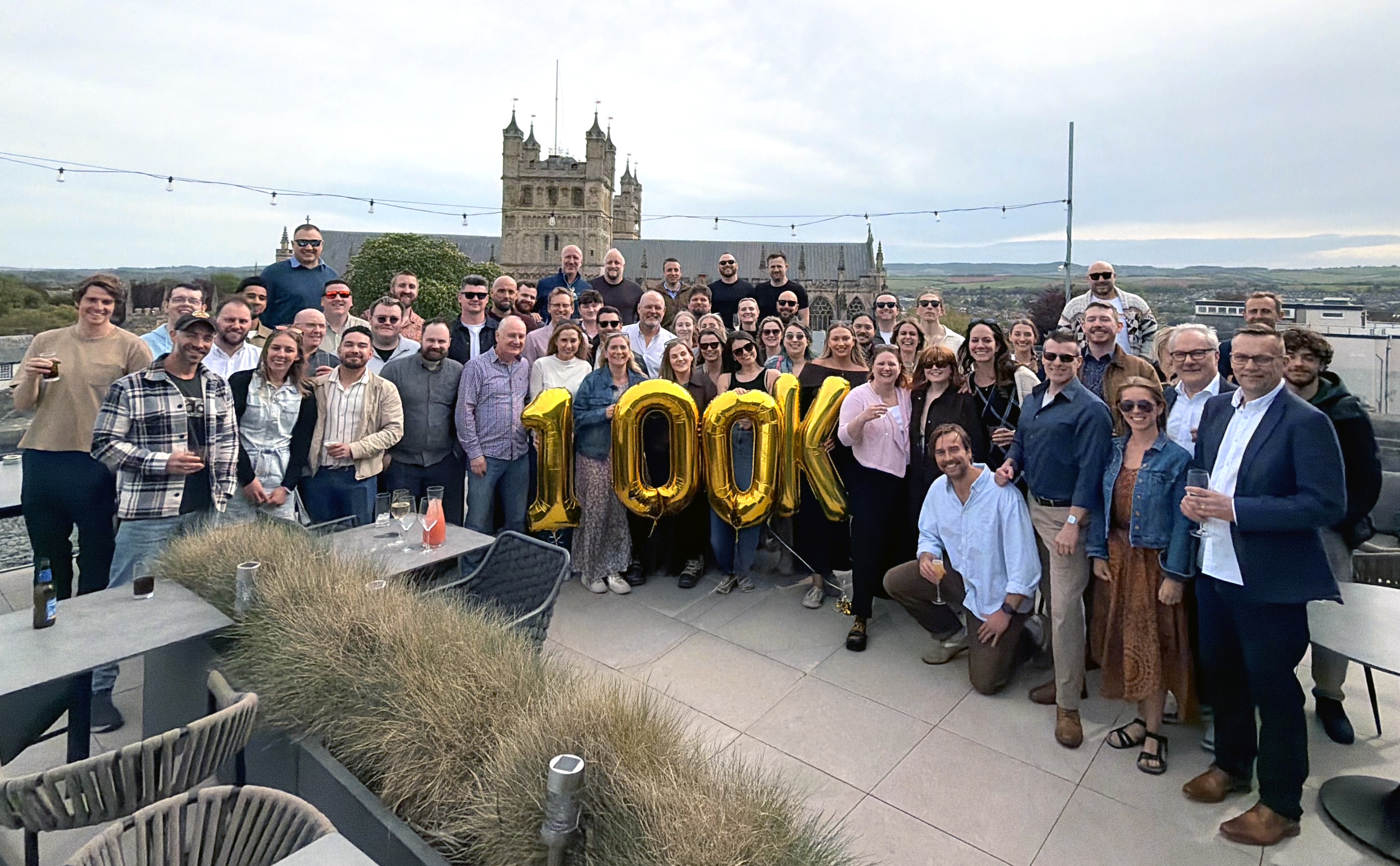 Lightfoot team gathering with gold 100K balloons and Exeter Cathedral in the background
