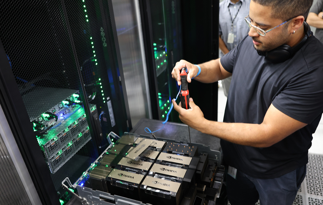 An engineer working among densely wired GPU racks