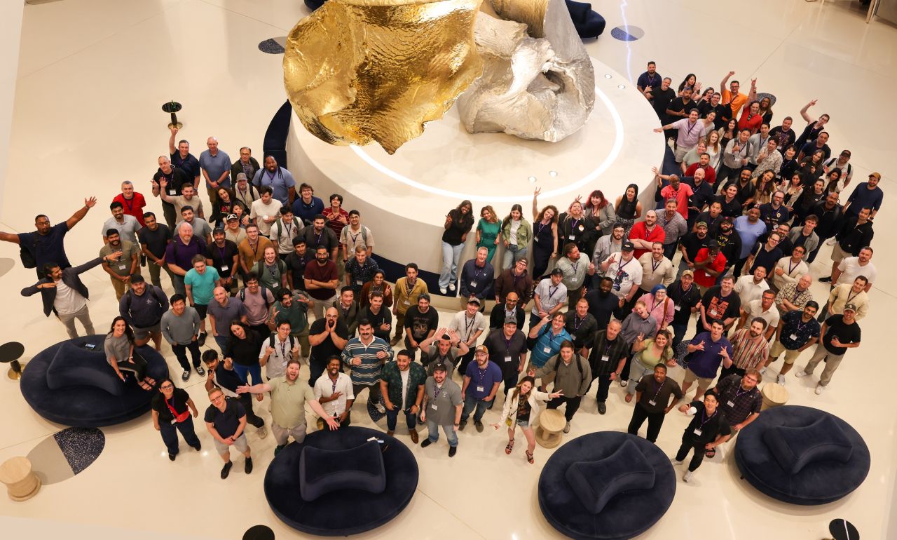 Lightning AI team gathered around a large sculpture, looking up at the camera