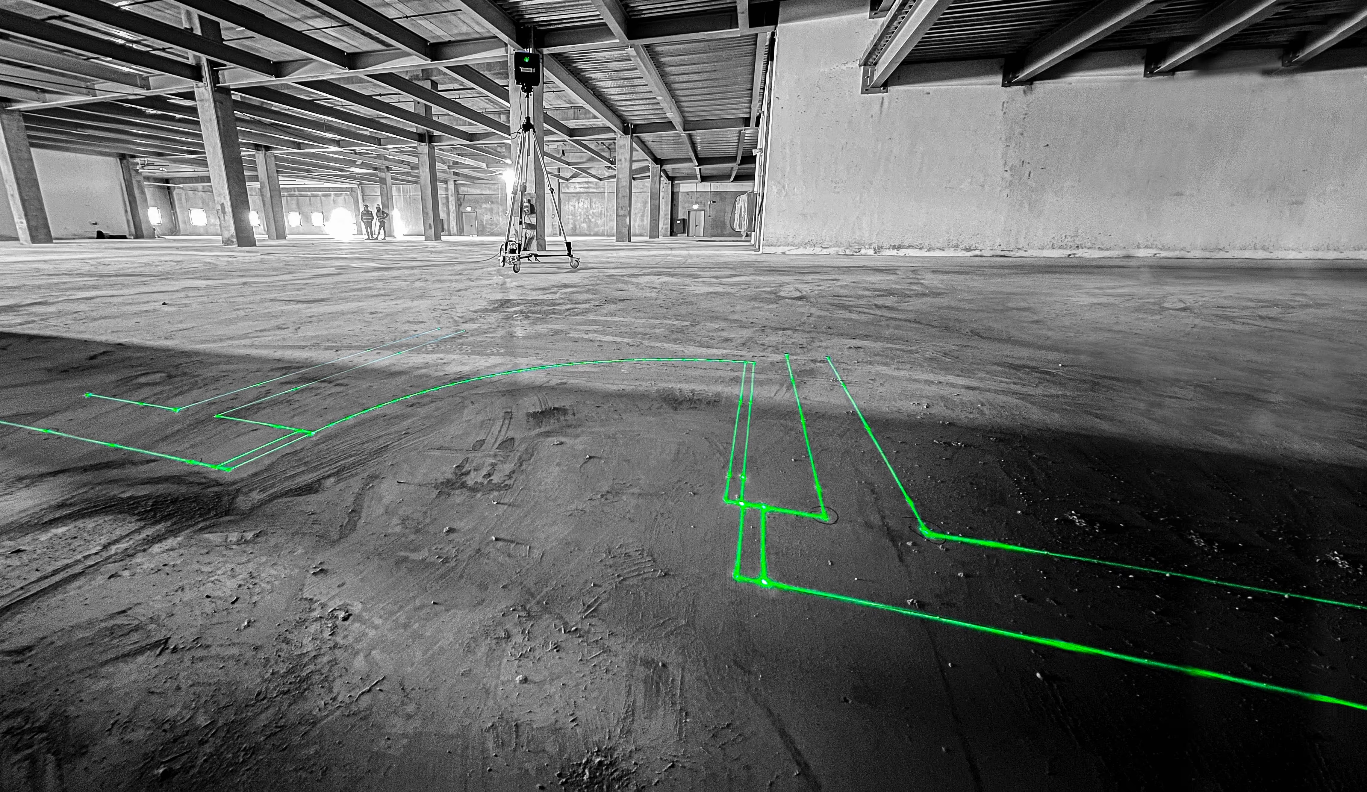 LightYX BeamerOne projecting green construction layout lines on a concrete floor