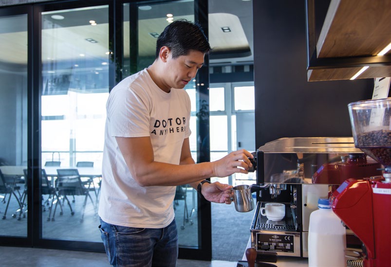 Lim Wai Mun preparing coffee at the office espresso machine