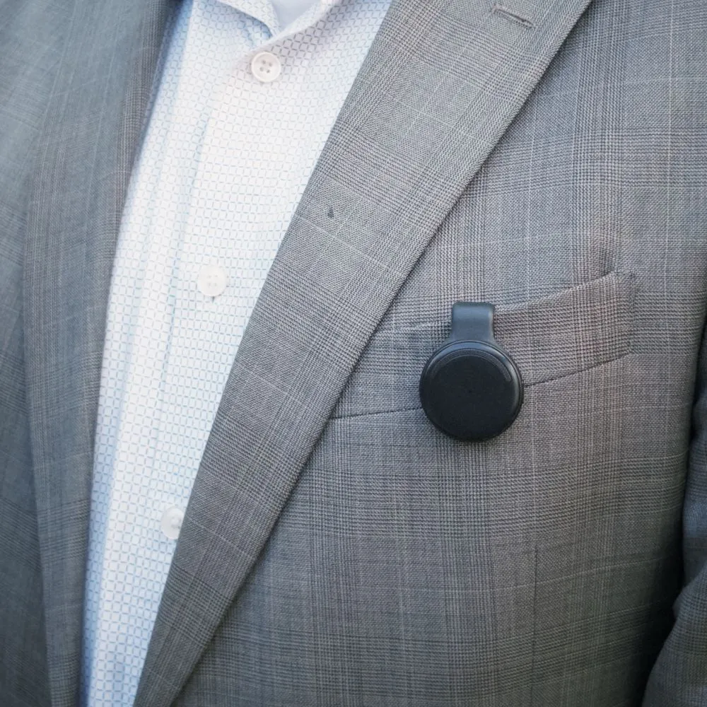 Black Limitless Pendant clipped to the breast pocket of a gray suit