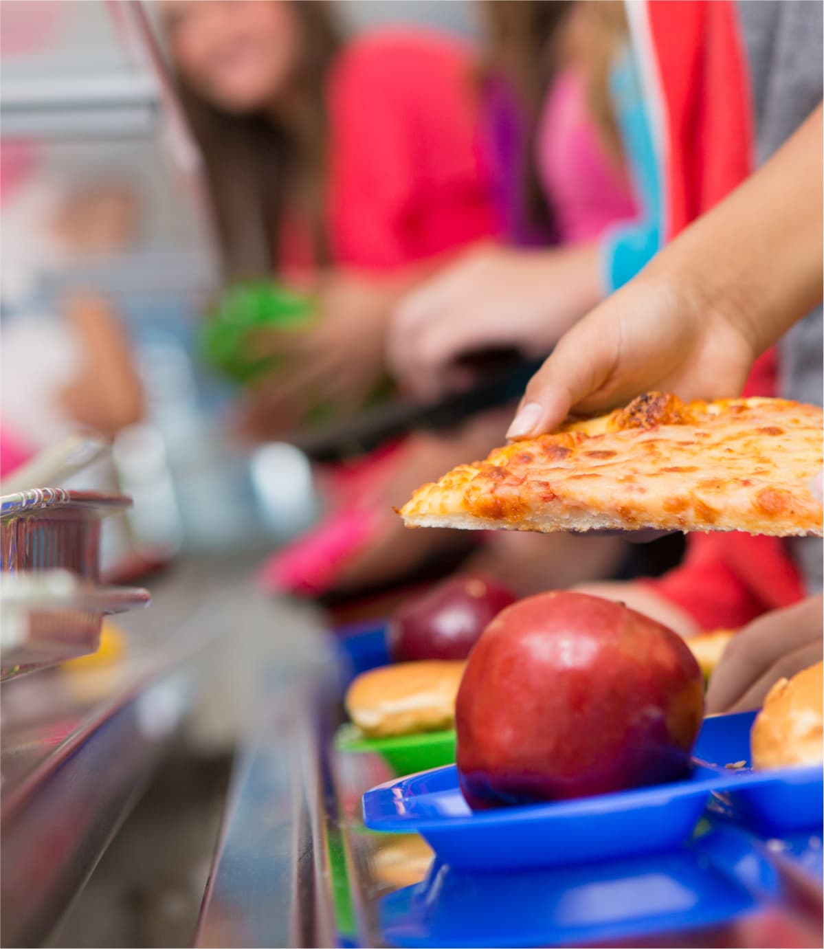 A slice of pizza being served onto a school lunch tray
