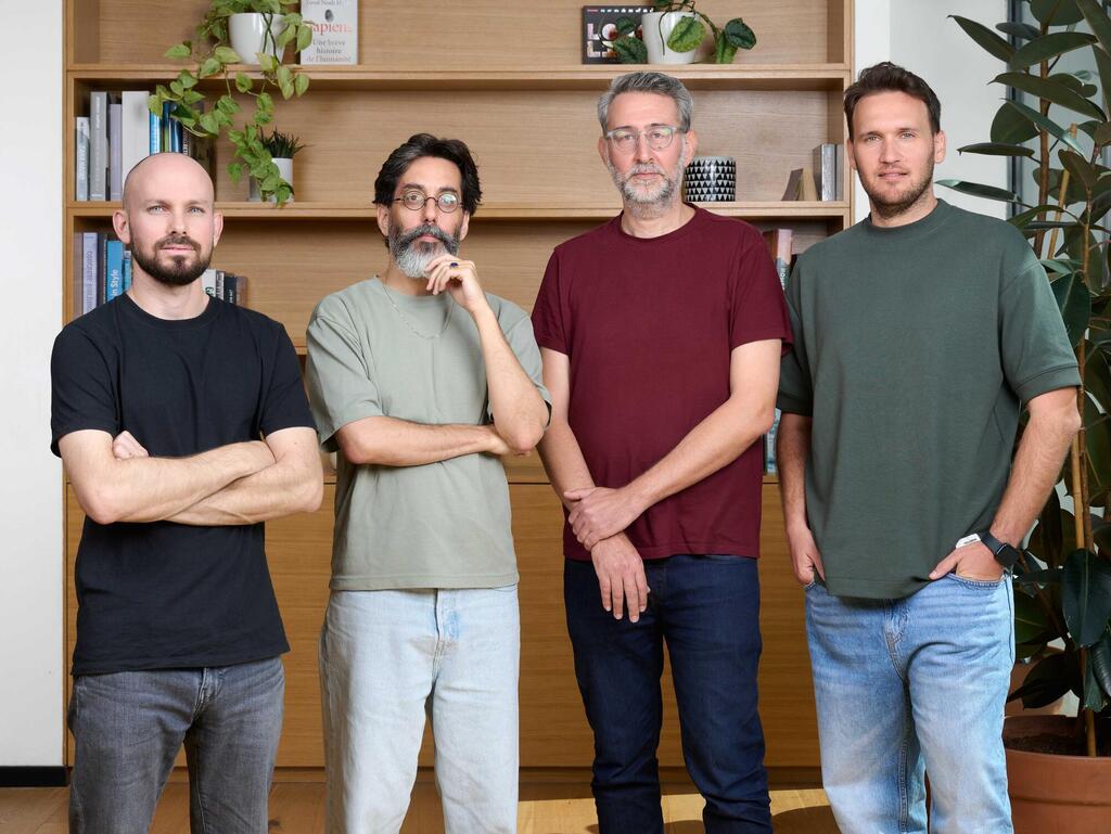 Weavy’s four co-founders standing together in front of bookshelves and plants