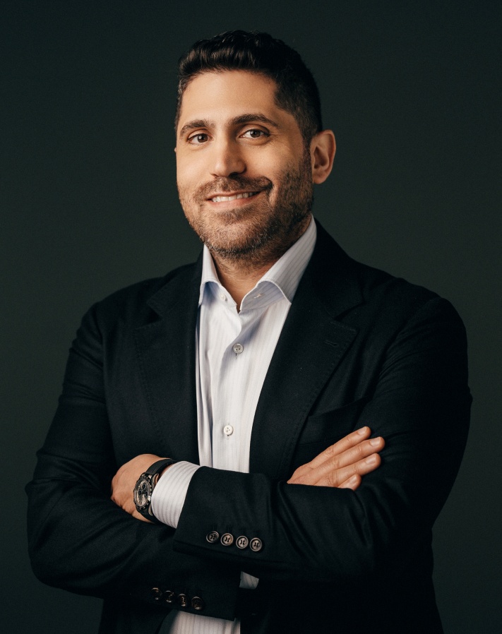 Lior Tamir standing with his arms folded in a dark jacket