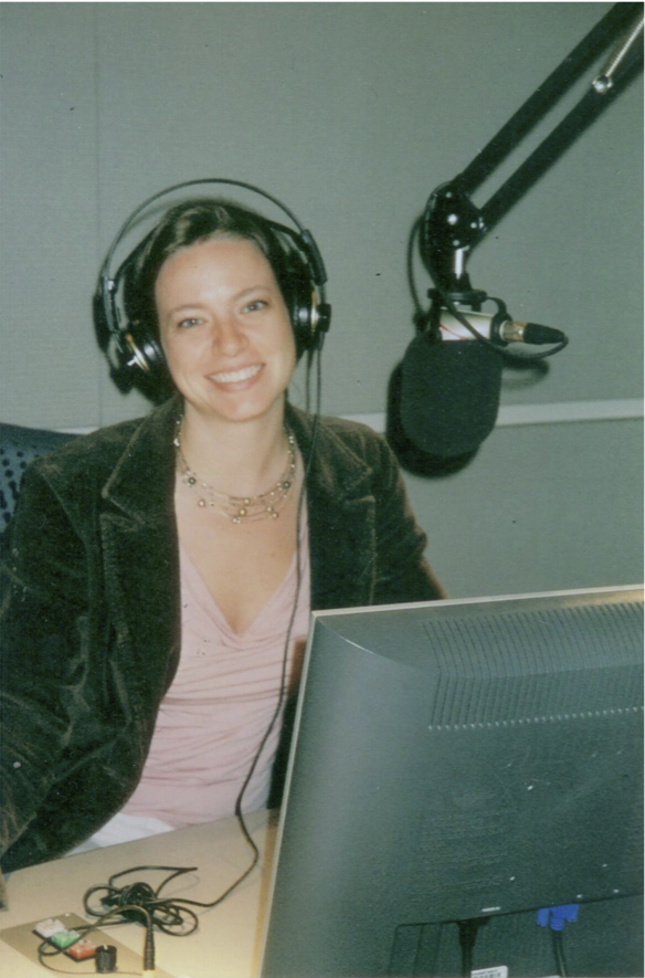Lisa Ann Pinkerton wearing headphones at a radio studio microphone