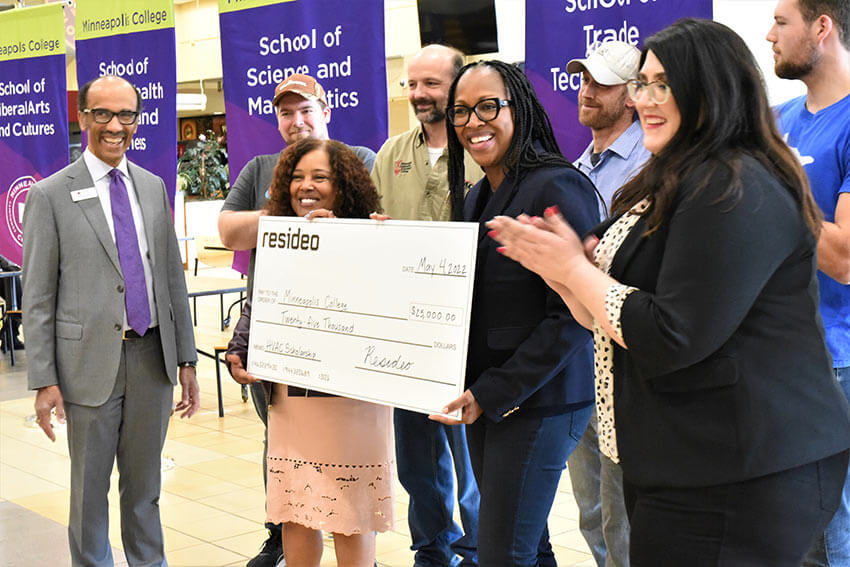 Lisa Armstrong and Resideo colleagues present an oversized donation check at Minneapolis College