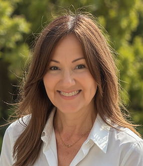 Lisa Purdum smiling outdoors in a white shirt