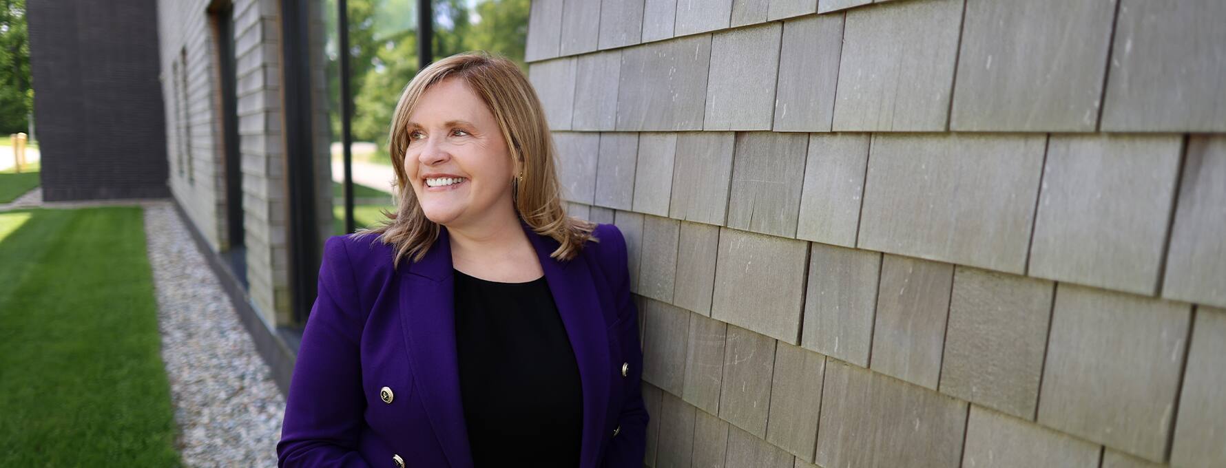 Lisa Marsh Ryerson in a purple jacket standing outside on the Southern New Hampshire University campus