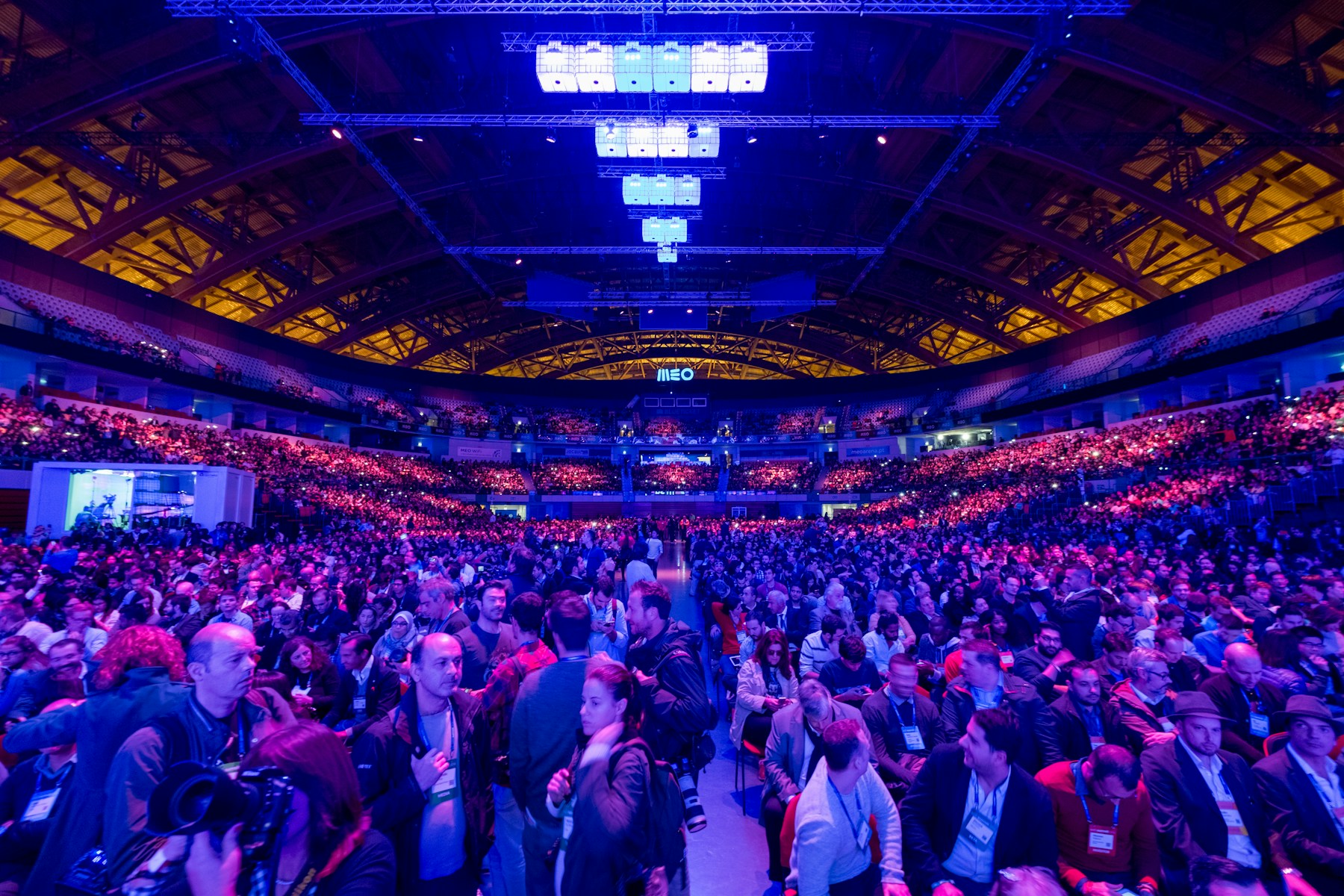 A large audience seated inside Lisbon’s Web Summit arena under blue and magenta lights