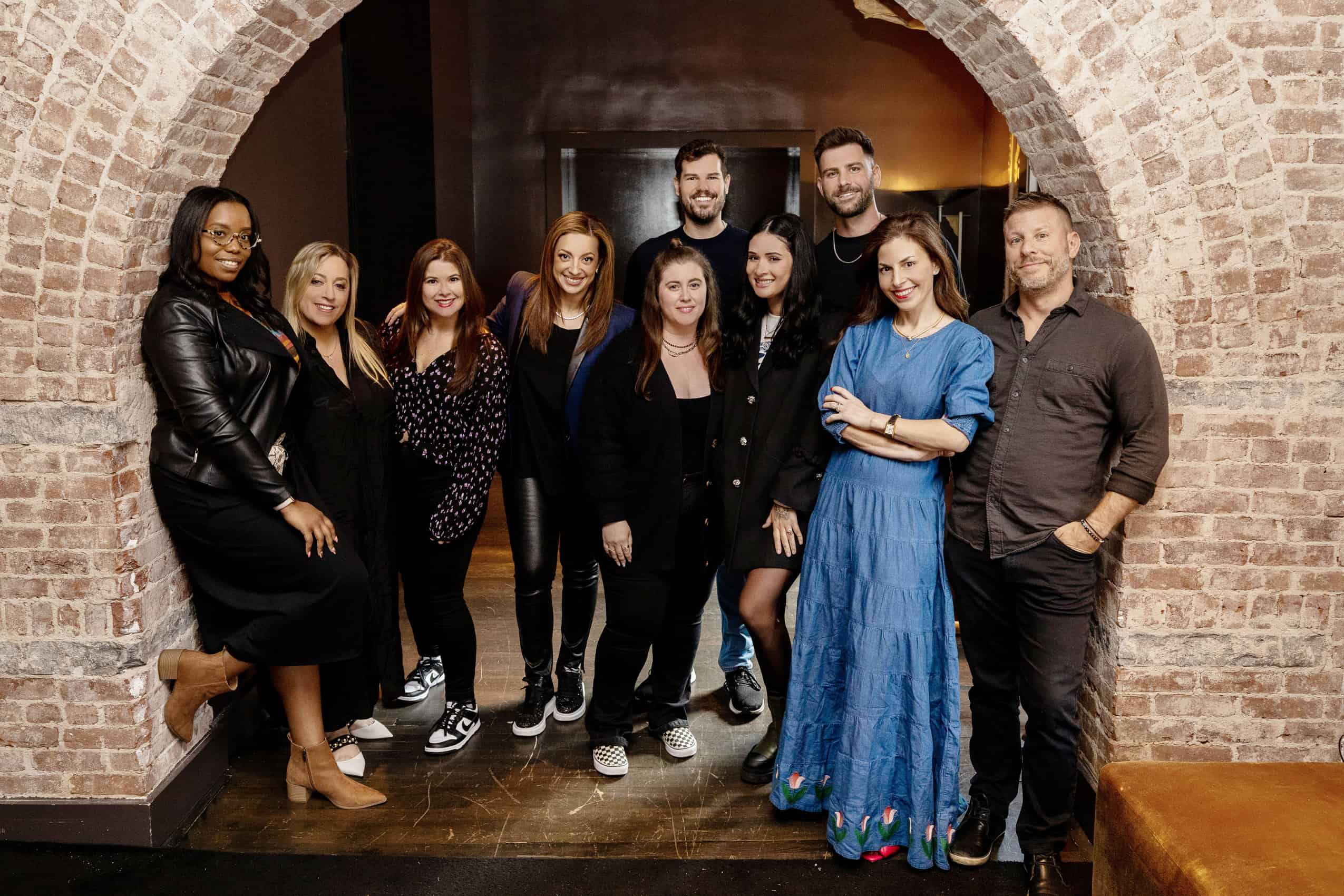 SHADOW’s executive team gathered beneath a brick arch in 2022, with Lisette Sand-Freedman second from left in the front row