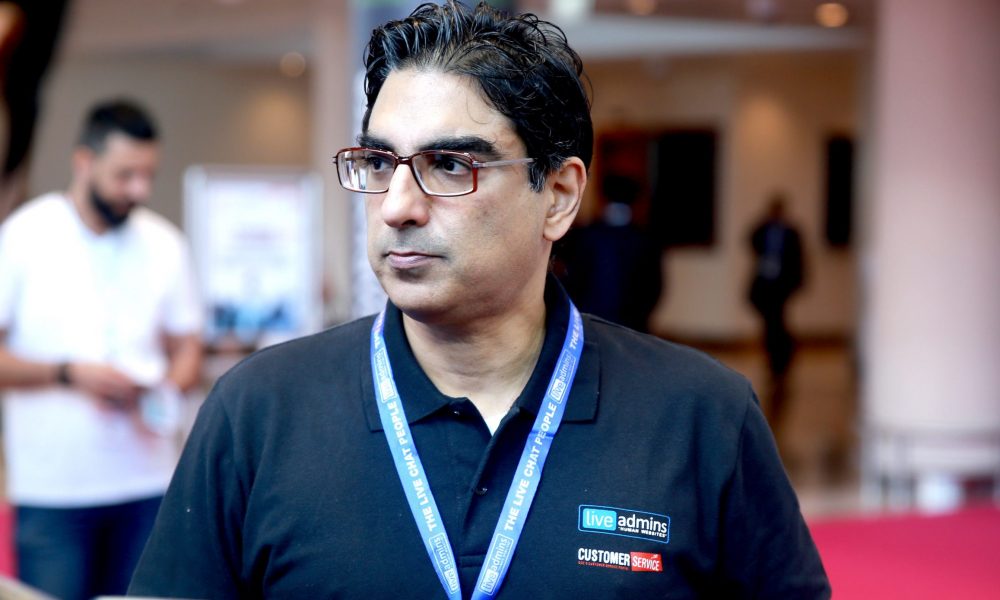 LiveAdmins founder Farrakh Azhar wearing a company polo shirt and event lanyard