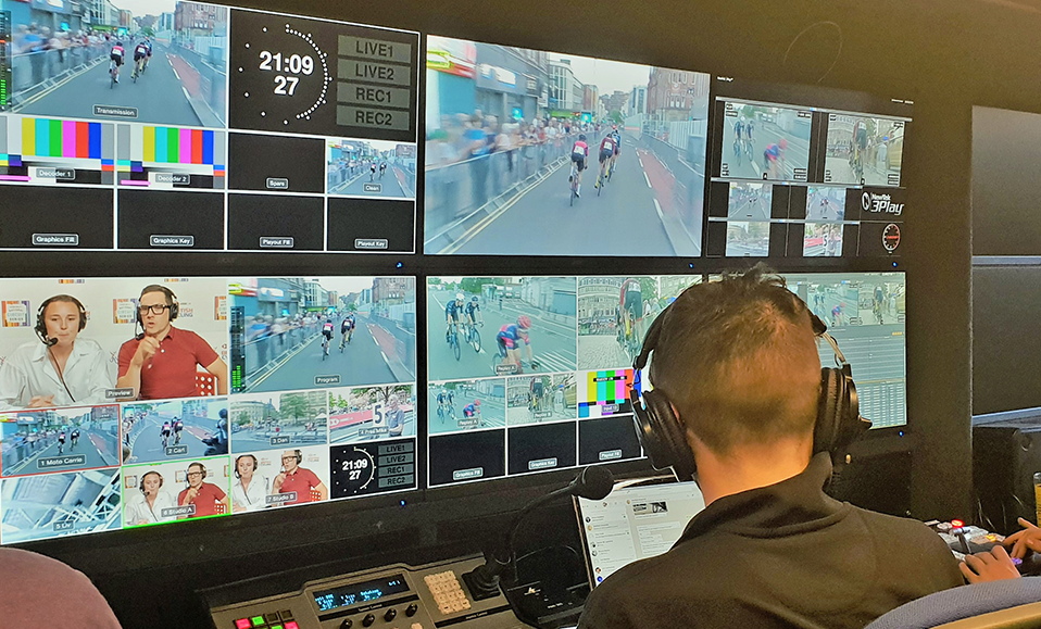 A production operator monitoring multiple camera feeds from a cycling race