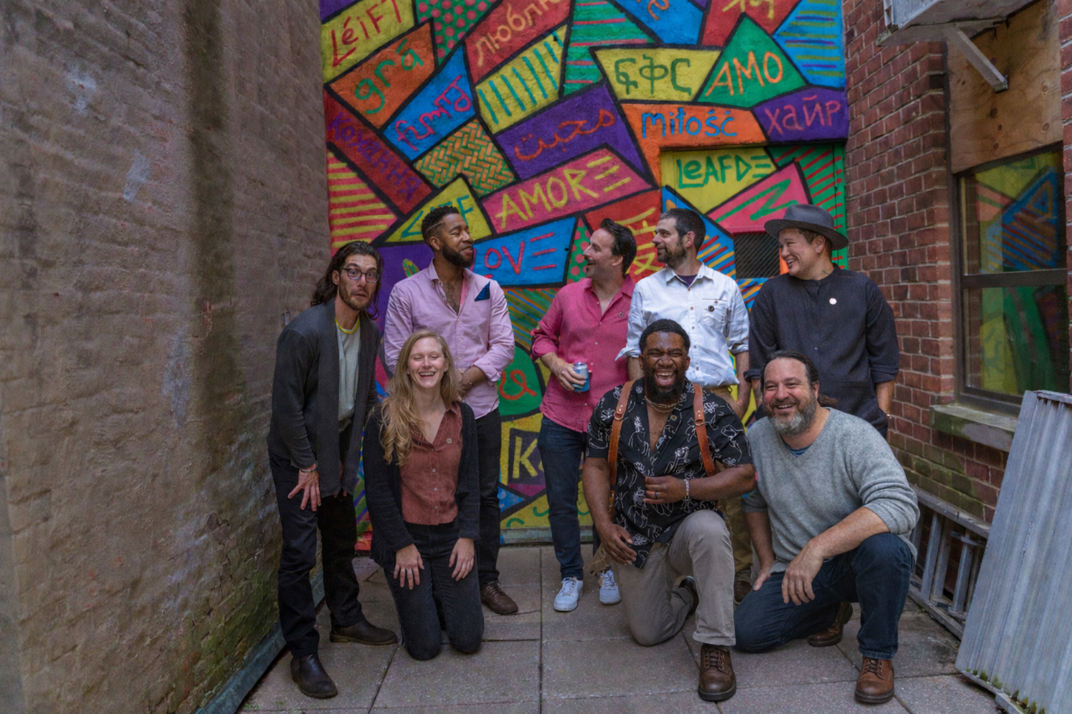 Members of the Living in the Light team laughing together in front of a colorful mural