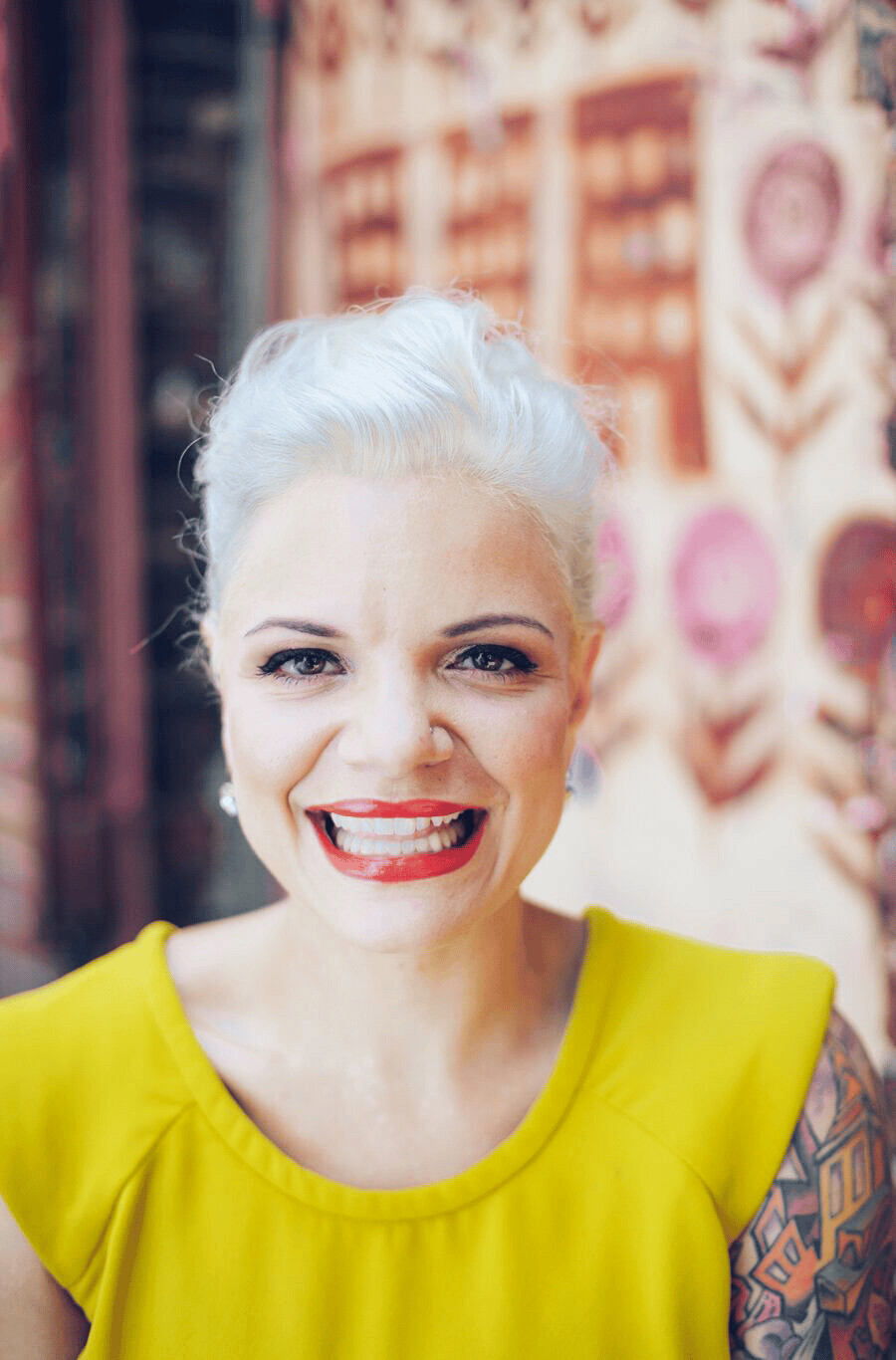 Liz Castelli smiling in a bright yellow top