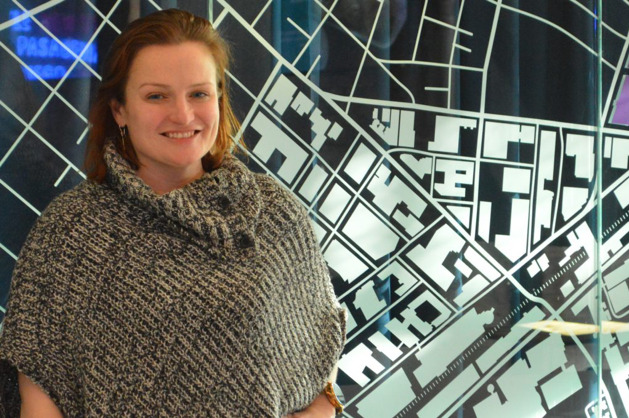 Liz O'Day standing in front of a graphic map at a Massachusetts life sciences event