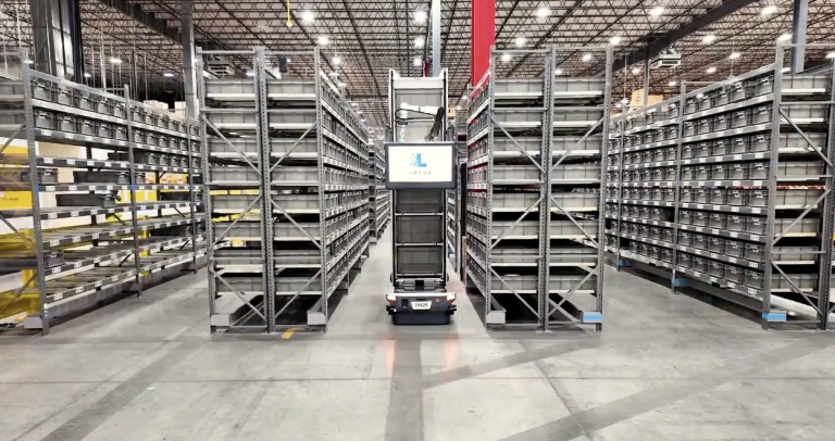 Locus Array mobile robot with a tall tote tower in an aisle of warehouse shelving