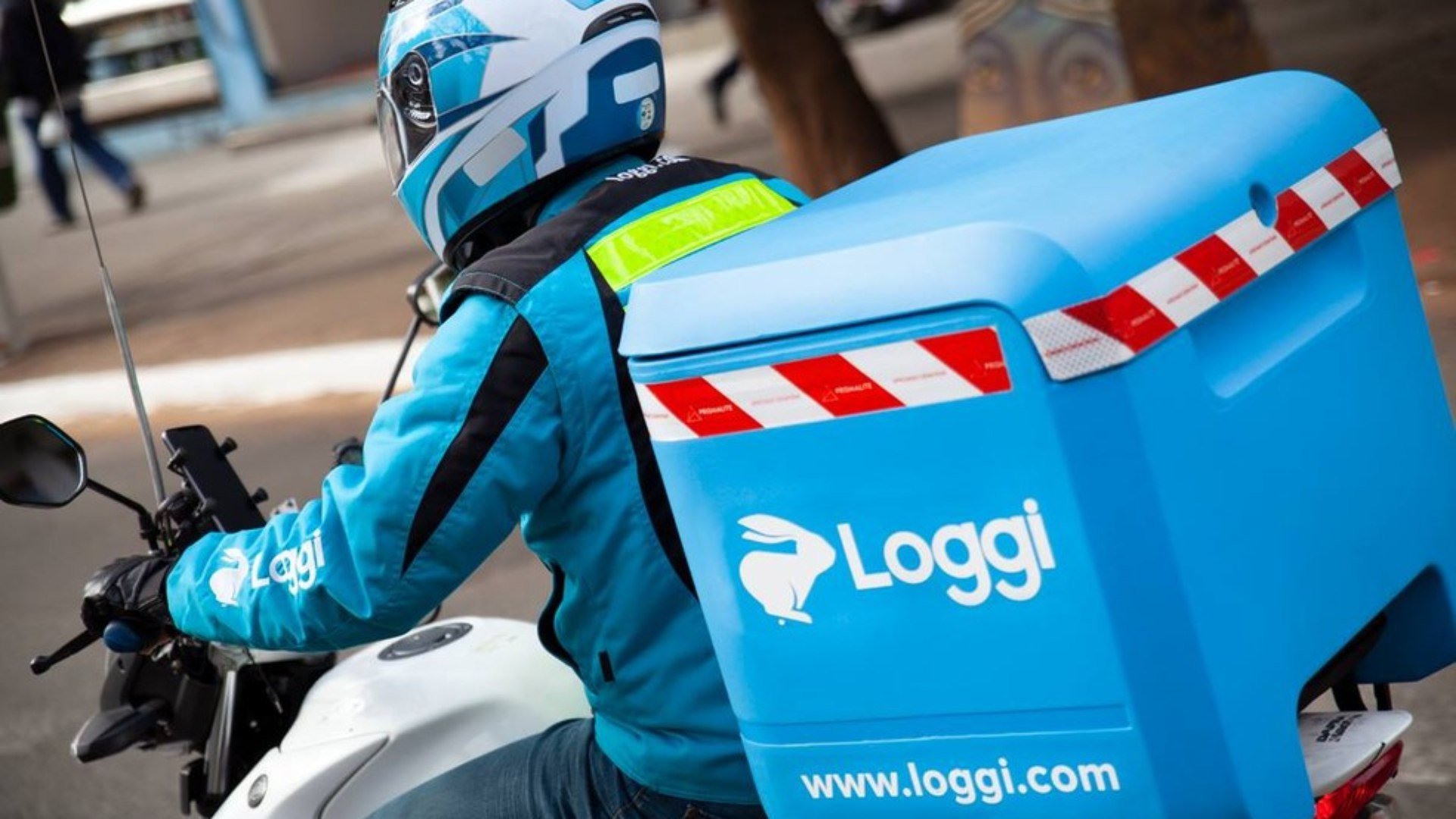 A motorcycle courier carrying Loggi’s familiar blue parcel box