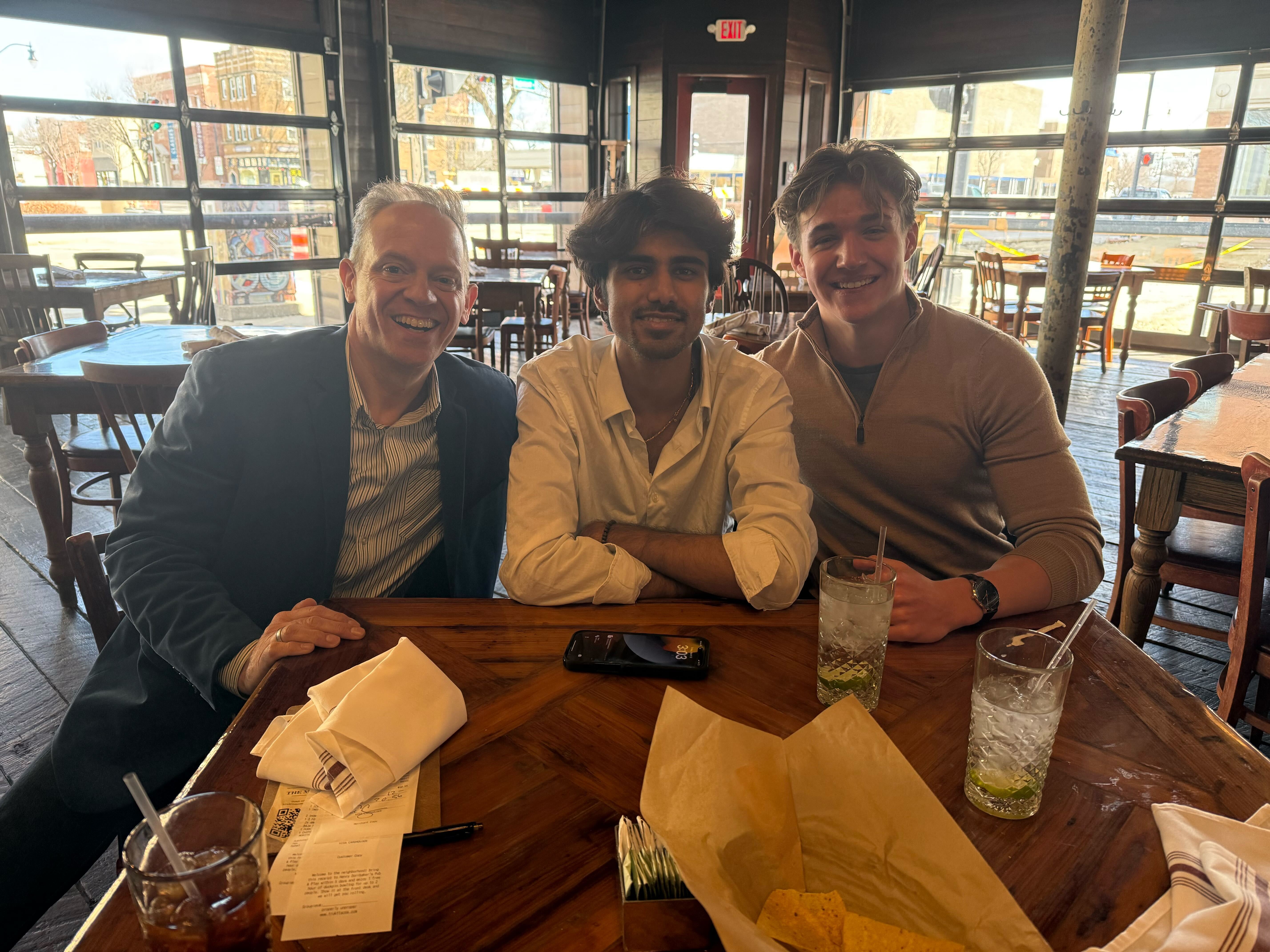 Loki Cheema seated with two colleagues and a guest around a restaurant table