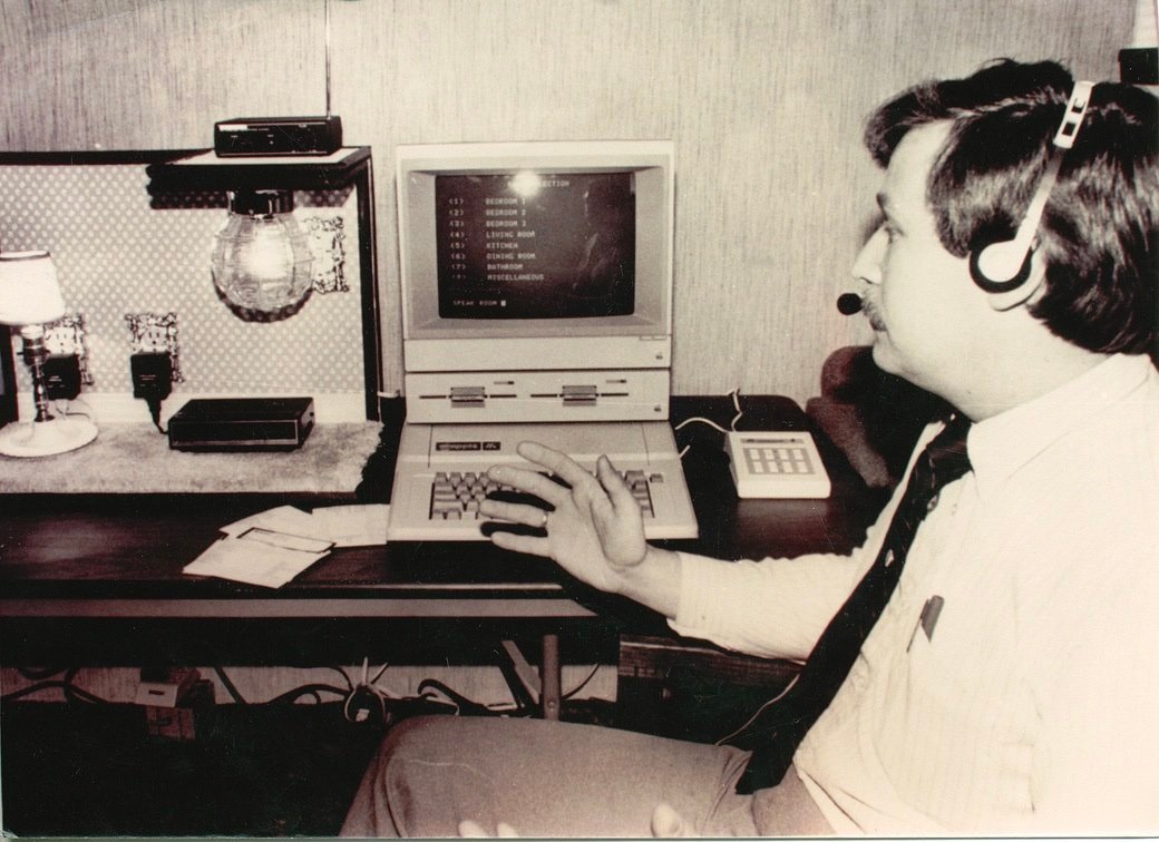 Lon Safko wearing a headset beside an early SoftVoice computer and a demonstration lamp