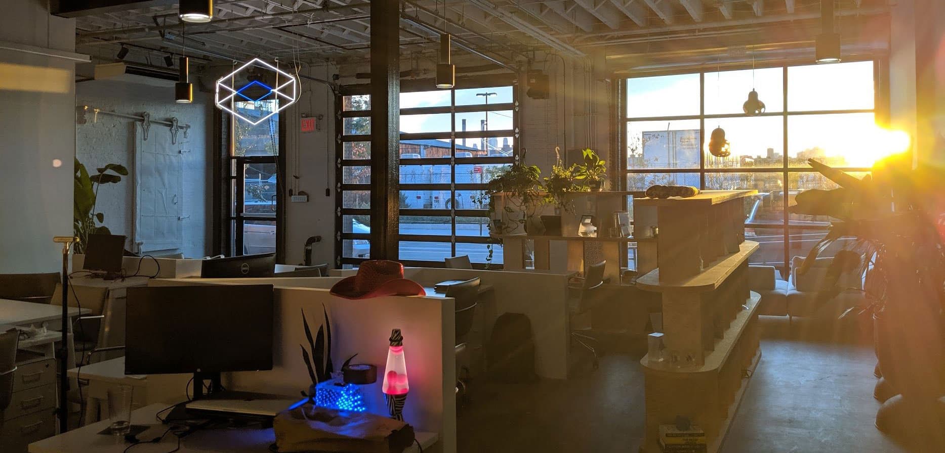 Looking Glass’s studio with workstations, windows and a suspended geometric light