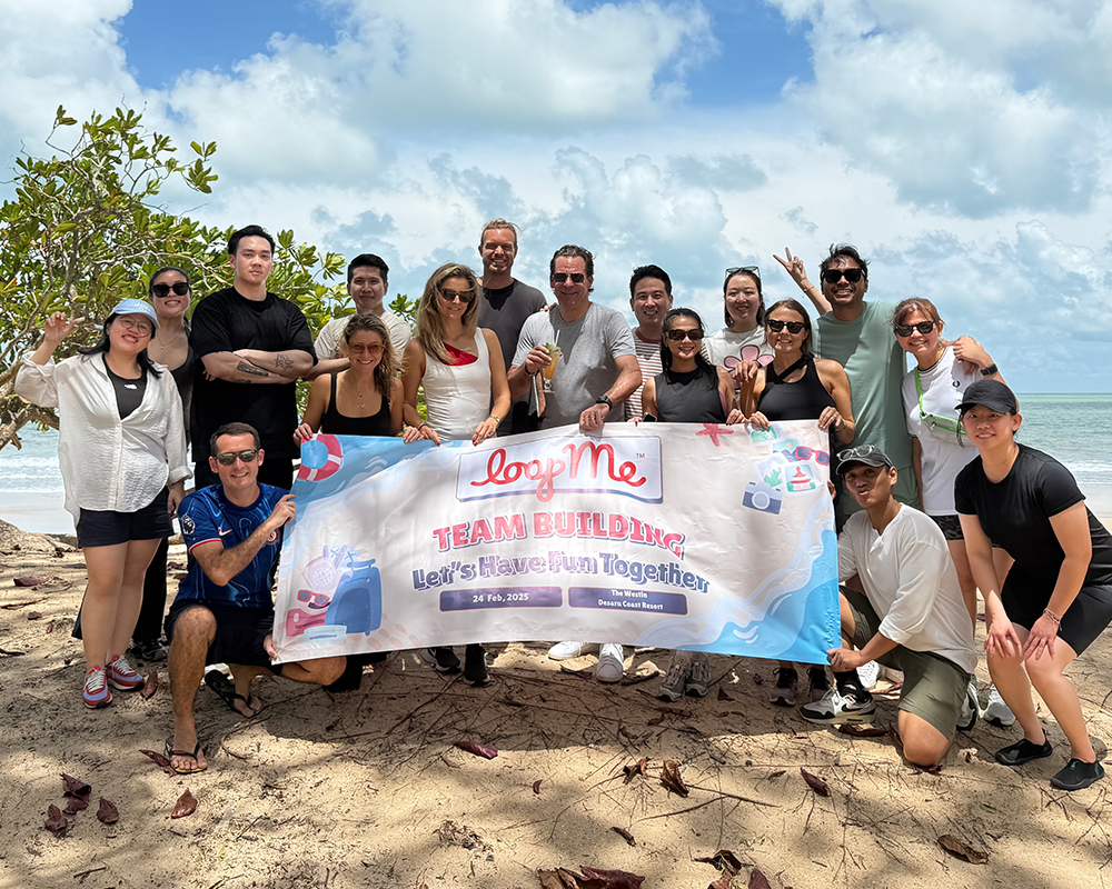 LoopMe APAC colleagues gathered on a beach in Malaysia at a February 2025 team-building event