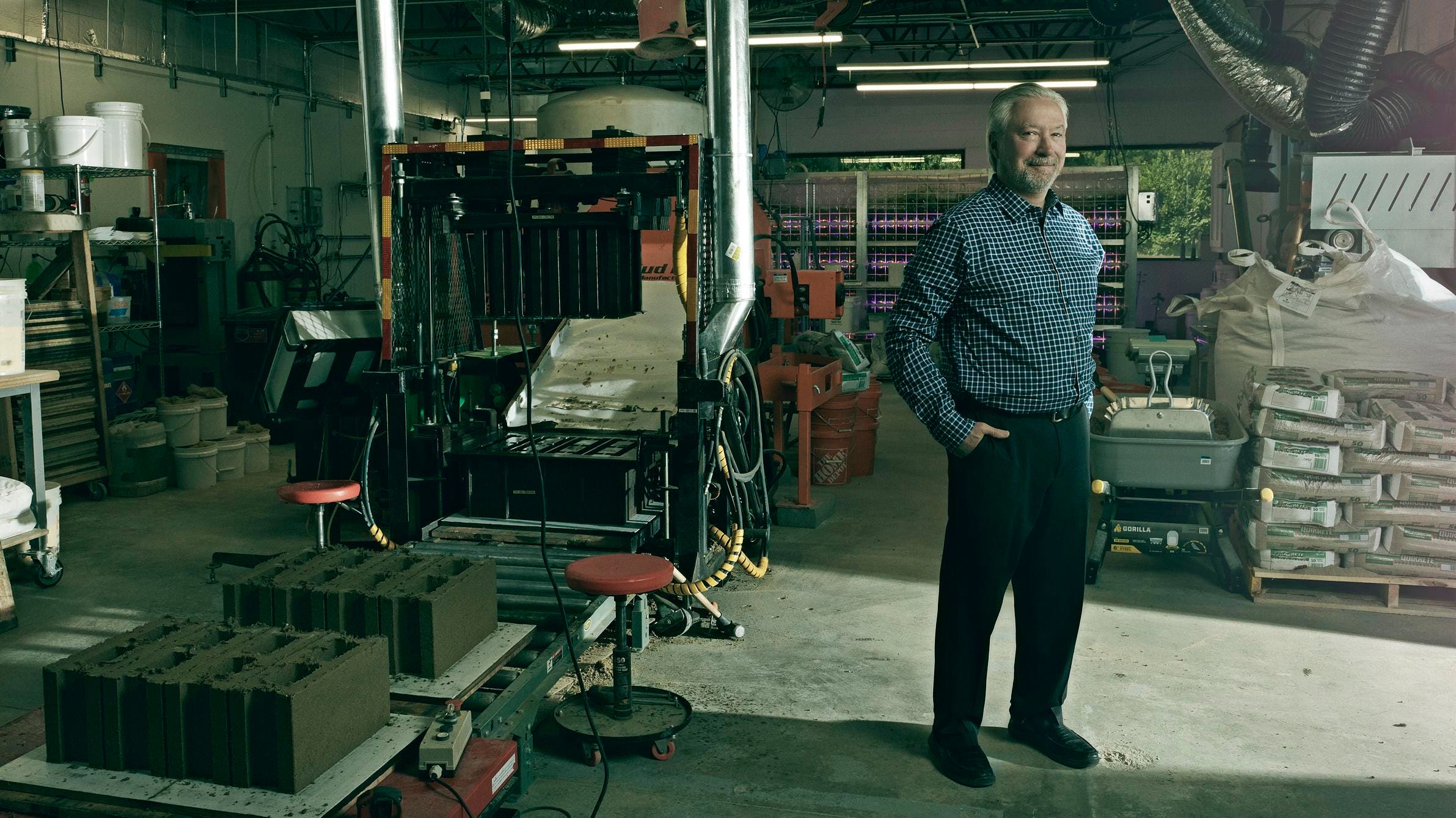 Loren Burnett standing among equipment at the Prometheus Materials bio-cement pilot plant