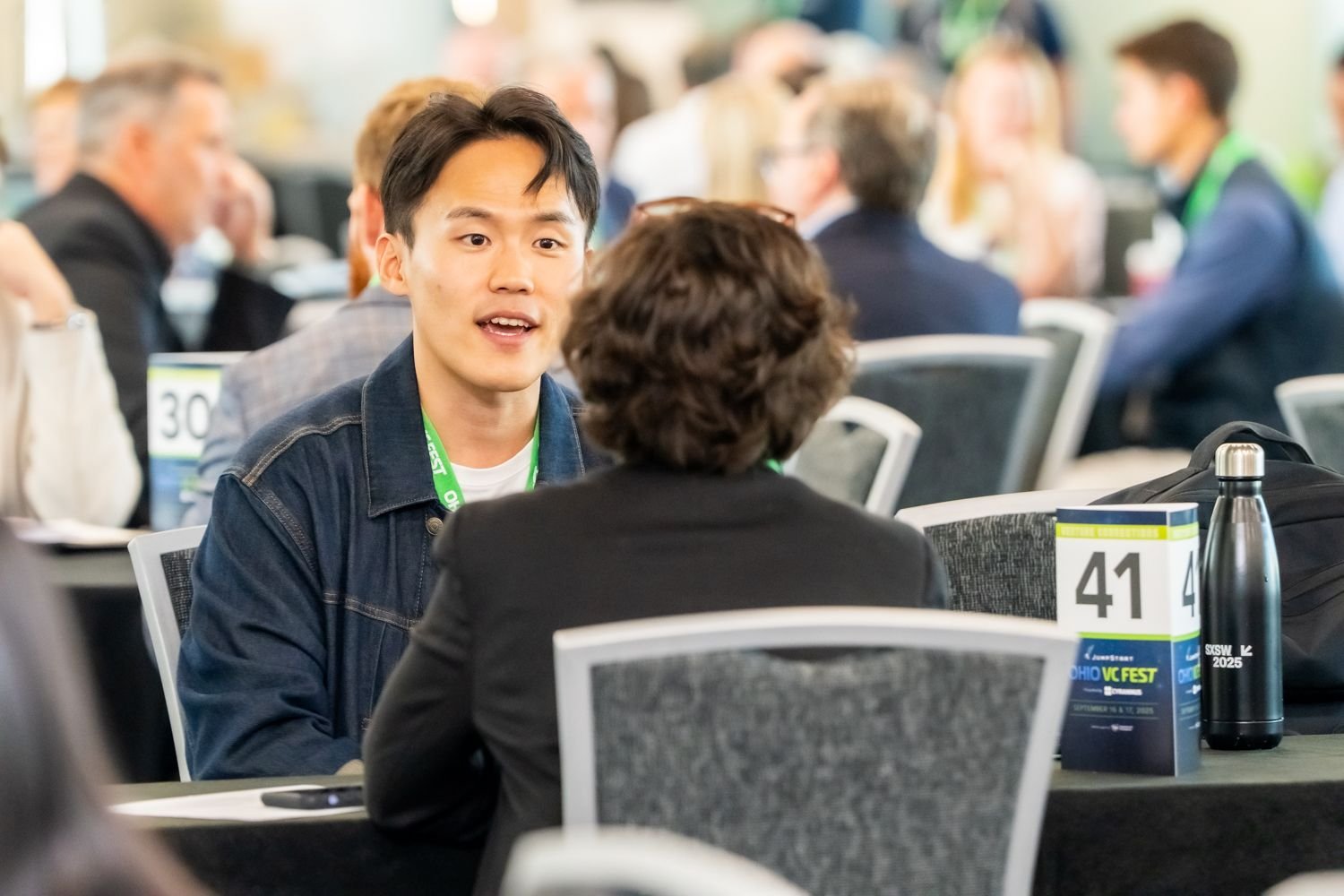 A founder and investor speaking across a numbered table at Ohio VC Fest 2025