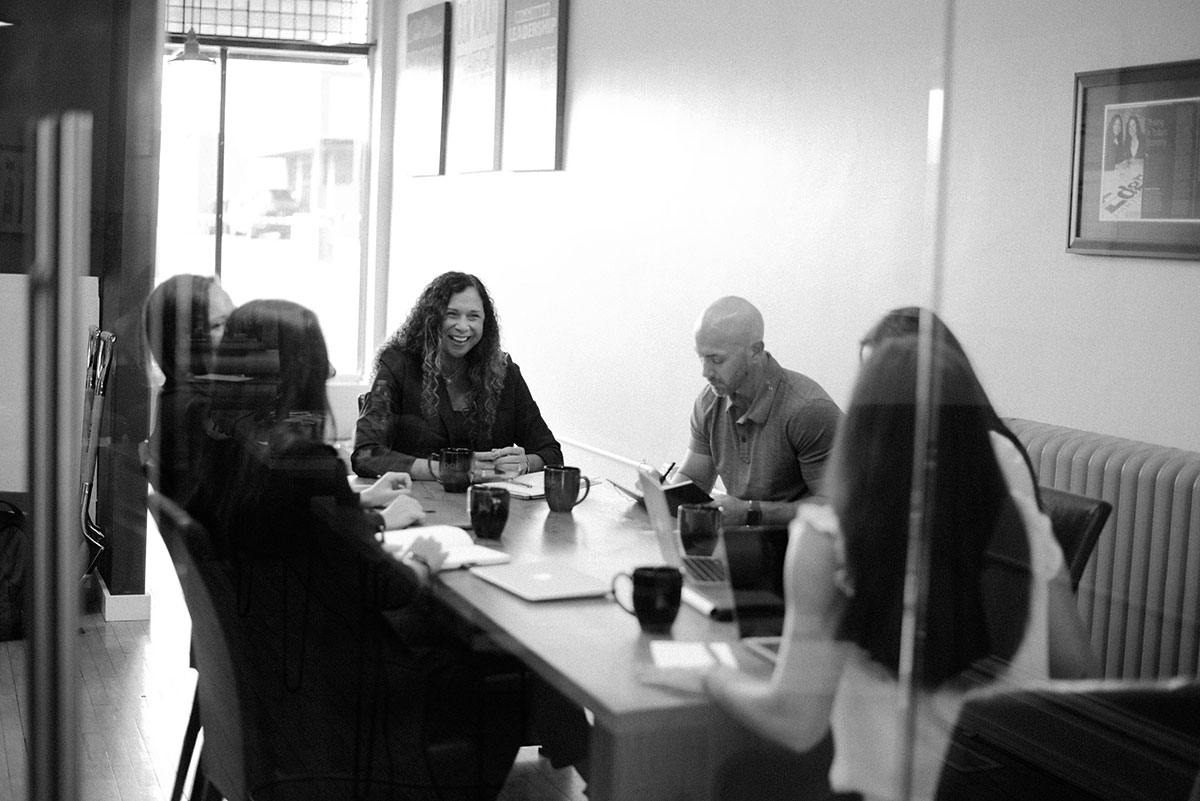 Lorri Rishar Jandron smiling with colleagues around an Edge meeting table
