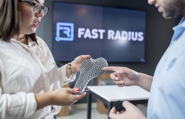 Two people examining a lattice-shaped manufactured component at Fast Radius