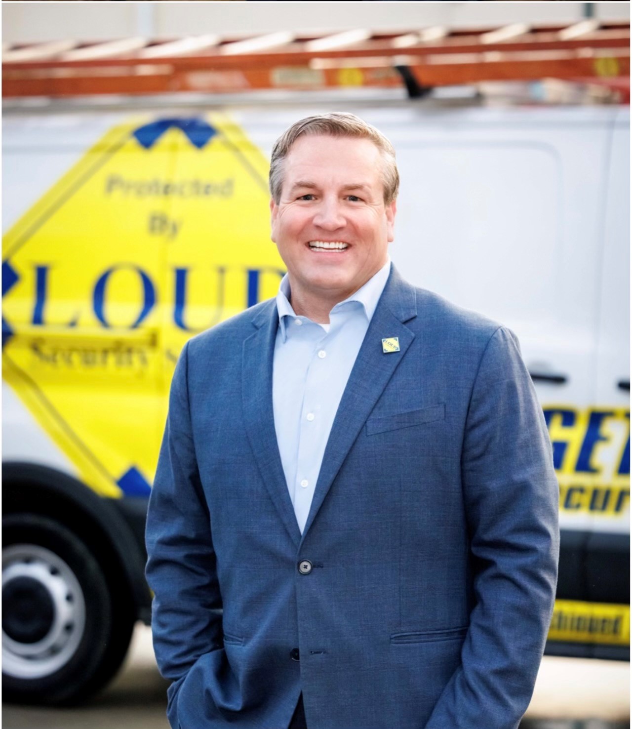 John Loud standing beside a LOUD Security service vehicle