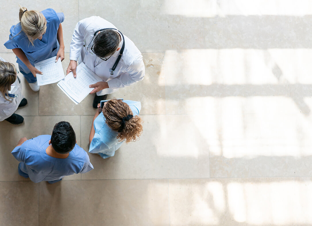 Health care professionals studying documents together in a bright hospital corridor
