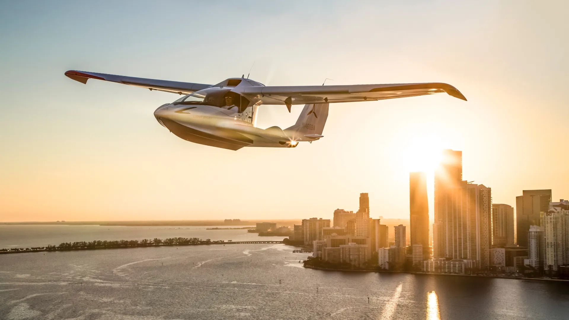 A small aircraft flying above a waterfront skyline at sunset, from Lovio George's Air Mobility Experience portfolio