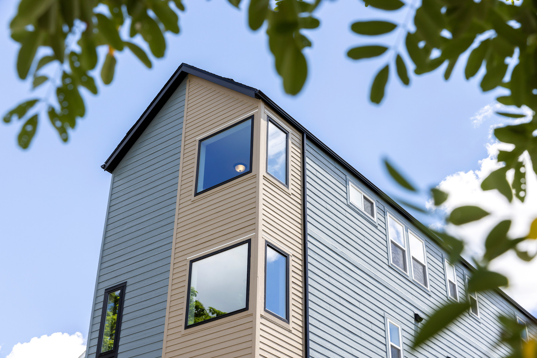 Gray and pale wood-tone horizontal SmartSide siding on a contemporary multistory building